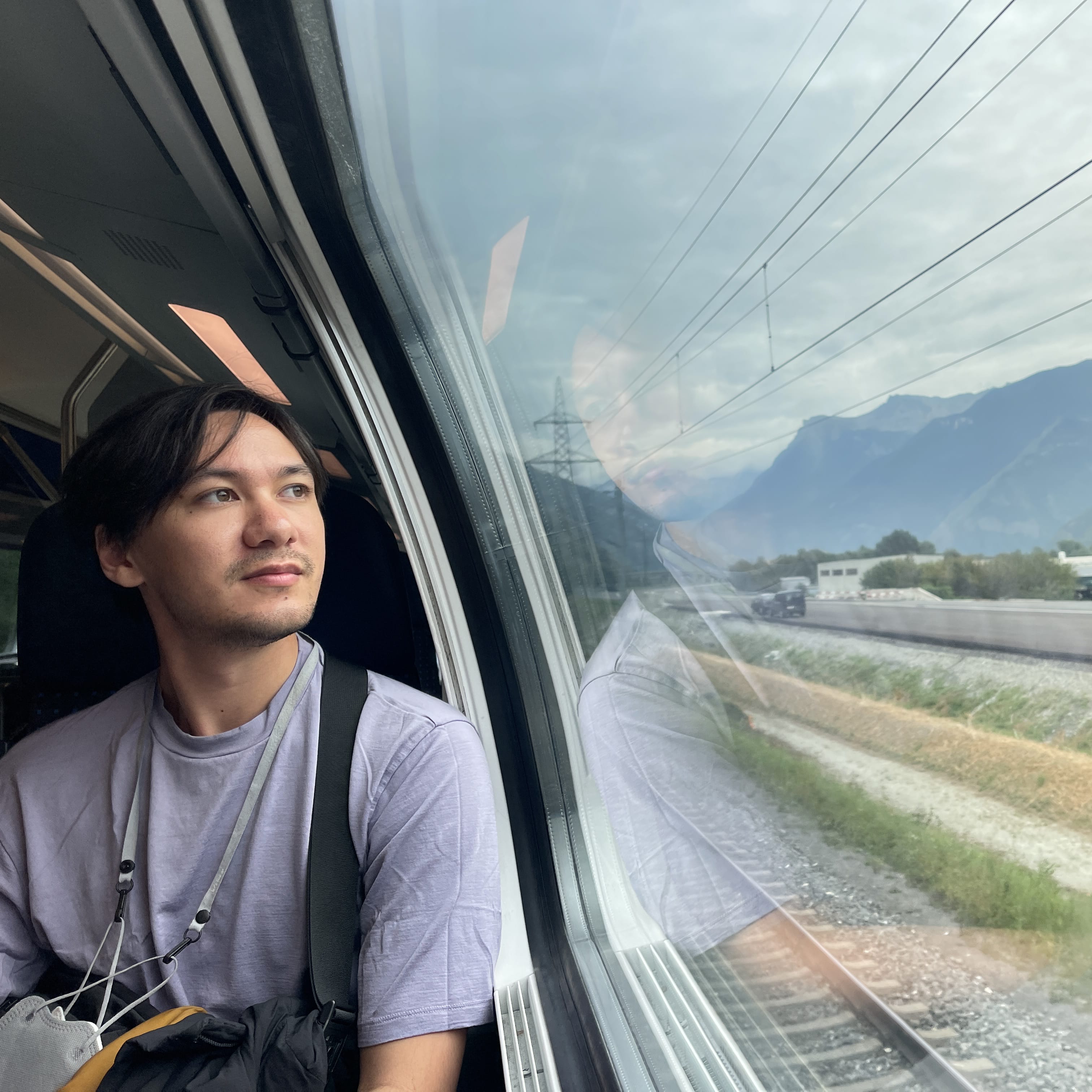 A picture of Teguh staring out of a train in Switzerland